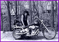 A woman sitting on the back of a motorcycle.